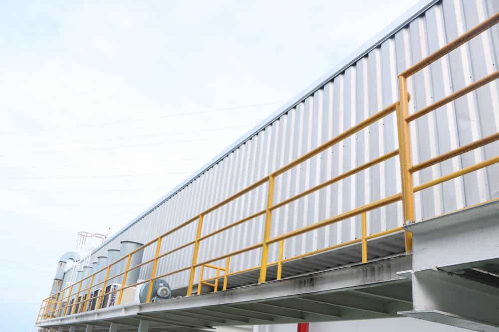 Yellow safety railing installed around the perimeter of a commercial building roof