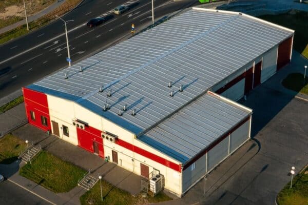 Aerial view of a large warehouse with metal roof and multiple exhaust fans