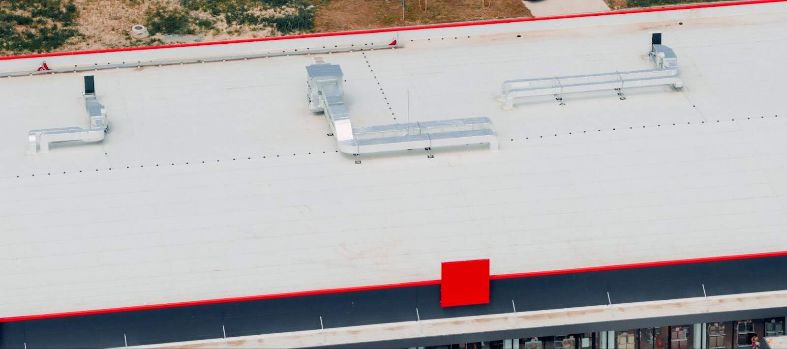 An aerial view of a PVC commercial roof highlights clean seams, HVAC equipment, and a well-installed membrane